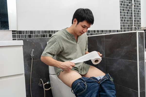 Hombre Con Problemas Estomacales Sentado Inodoro Sosteniendo Rollo Pañuelos Baño — Foto de Stock