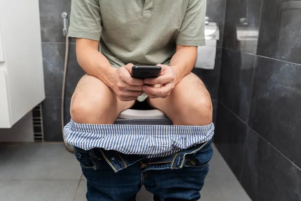 Man Using Smartphone Sitting Toilet Bowl Bathroom Home — Φωτογραφία Αρχείου