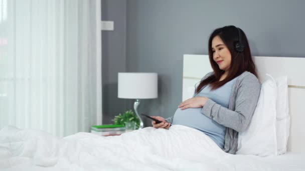 Gravid Kvinna Som Använder Smartphone För Att Lyssna Musik Hörlurar — Stockvideo