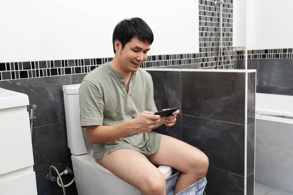 Hombre Feliz Usando Teléfono Inteligente Sentado Inodoro Baño Casa — Foto de Stock