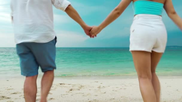 幸せな若いカップルが走り タイのラヨーン島のコ ムンノーク島の海のビーチで楽しんでいます — ストック動画
