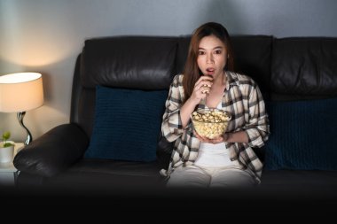 Genç bir kadın geceleri kanepede film izlerken şok olur.