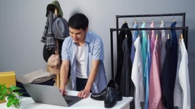 Genç adam internetten giysi ve aksesuar satıyor. Bilgisayarda canlı yayın yapıyor, iş dünyasında e-ticaret yapıyor.