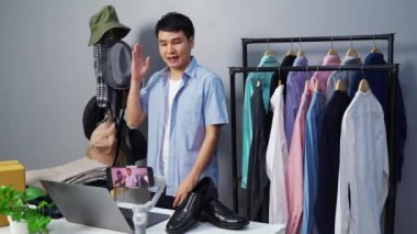 Genç adam online kıyafet ve aksesuar satıyor akıllı telefonuyla canlı yayın, iş dünyasında e-ticaret yapıyor.