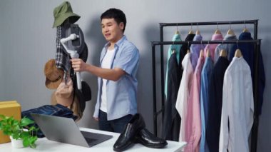 Genç adam online kıyafet ve aksesuar satıyor akıllı telefonuyla canlı yayın, iş dünyasında e-ticaret yapıyor.