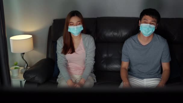 Jovem Casal Assistindo Sofá Usando Máscara Médica Para Proteger Coronavírus — Vídeo de Stock