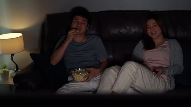Lustiges Junges Paar Fernsieht Und Abends Popcorn Auf Dem Sofa — Stockvideo