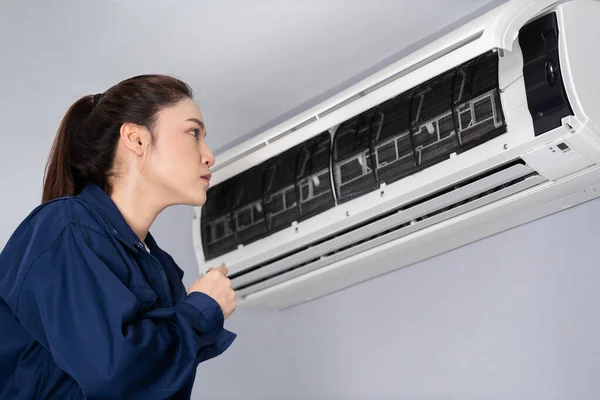 女性技术员检查和修理室内空调机 — 图库照片