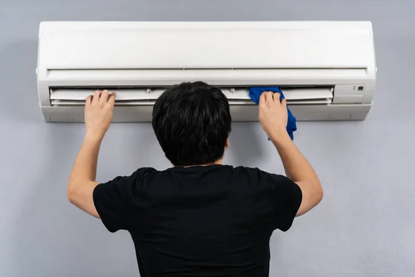 Jongeman Schoonmaken Van Airconditioner Met Doek Thuis — Stockfoto