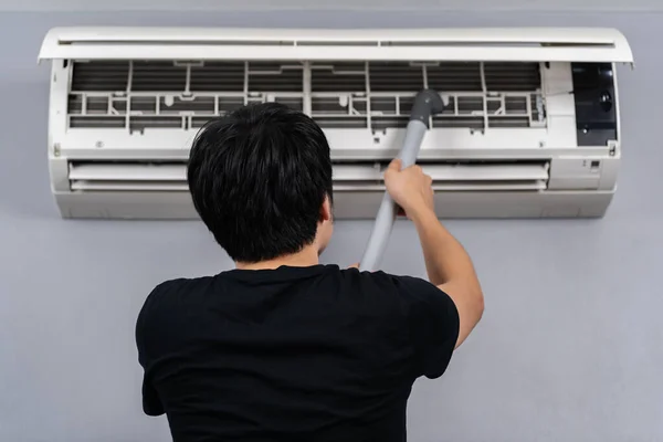 Jongeman Met Behulp Van Stofzuiger Airconditioner Thuis Schoon Maken — Stockfoto