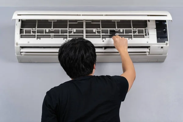 Jonge Man Met Behulp Van Borstel Het Schoonmaken Van Airconditioner — Stockfoto