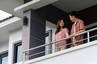 happy couple talking on balcony at home