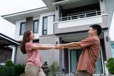 Evlerinin önünde dikilen neşeli genç çift.