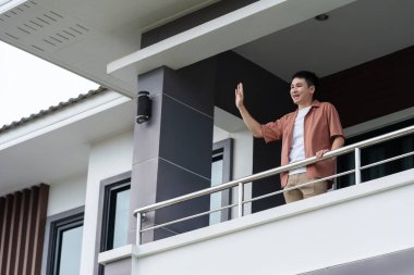 quarantine man greeting his neighbors from balcony of home, coronavirus pandemic