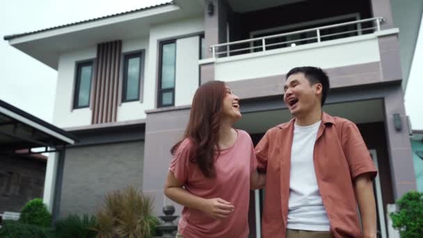 彼らの家の外に立つ陽気な若いカップルのスローモーション — ストック動画