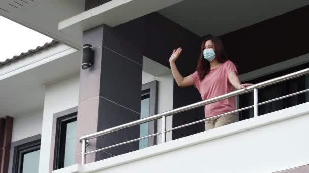 Карантинная Женщина Маске Лица Приветствуя Соседей Балкона Дома Падающим Дождем — стоковое видео