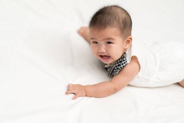 Yeni doğmuş bebek yatakta ağlıyor.