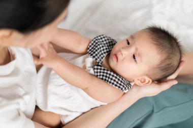 Anne yeni doğmuş bebeği şefkatle kucağında tutuyor.