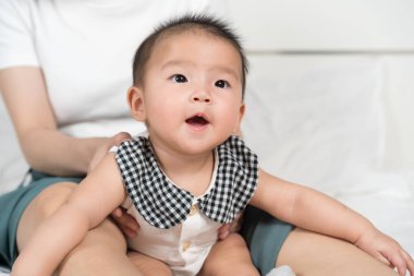 Mutlu bir bebek ve anne evde bir yatakta