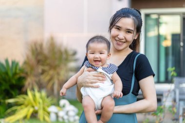 Mutlu bir anne yeni doğmuş bebeğini kucağında tutuyor.