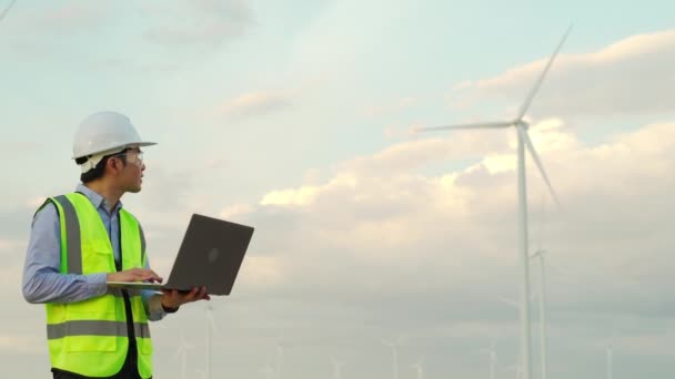 年轻的男性工程师用手提电脑对抗风力涡轮机农场 — 图库视频影像