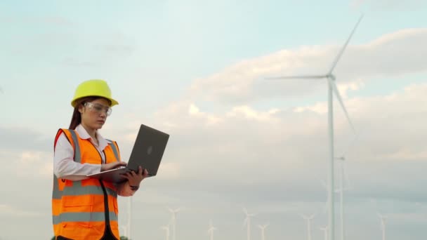 Joven Ingeniera Que Trabaja Con Ordenador Portátil Contra Parque Eólico — Vídeo de stock