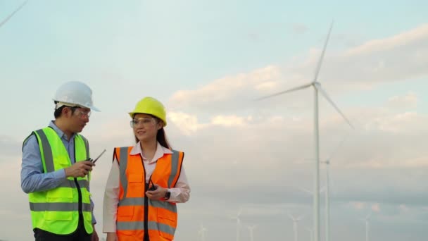 Unga Ingenjör Team Talar Och Arbetar Mot Vindkraftverk Gård — Stockvideo