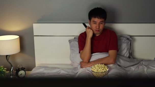 夜にベッドでテレビを見て退屈若い男 — ストック動画