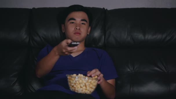 Joven Alegre Sosteniendo Control Remoto Viendo Televisión Mientras Está Sentado — Vídeos de Stock