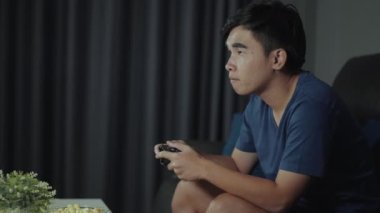 Genç adam video oyunu oynuyor ve geceleri kazanıyor.