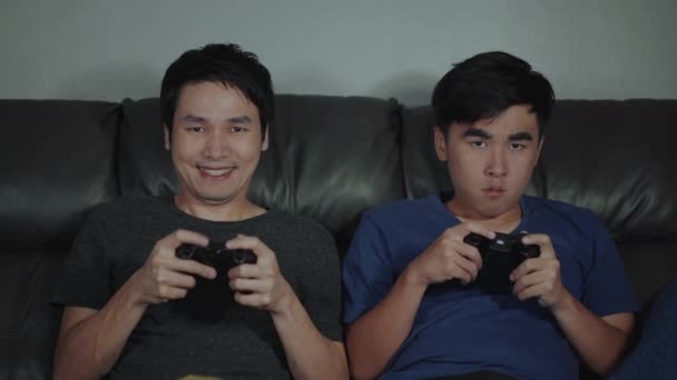两个男人坐在沙发上玩电子游戏 赢得和失去感情 — 图库视频影像