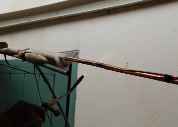 Repairman welding copper pipes — Stock Photo, Image