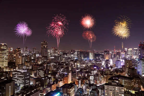 夜の東京の街並を祝う花火 — ストック写真