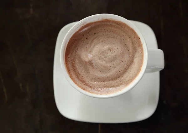Chocolate caliente en una taza blanca en la mesa —  Fotos de Stock