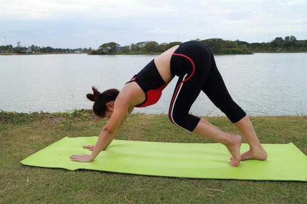 Young woman doing yoga exercise in the park — Stock Photo, Image