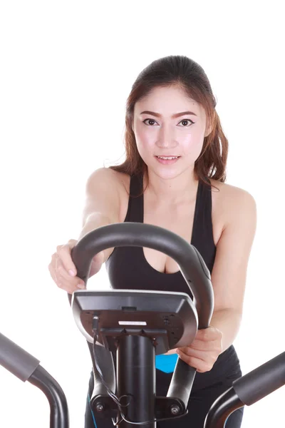 Ung kvinde laver øvelser med træningsmaskine - Stock-foto