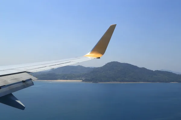 Tragfläche eines Flugzeugs, das über dem Meer und Strand fliegt — Stockfoto