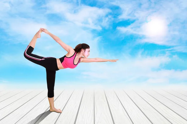 Mujer joven haciendo ejercicio de yoga en suelo de madera — Foto de Stock