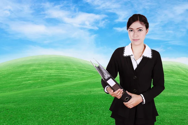 緑の芝生のフィールドとフォルダー内のドキュメントを保持しているビジネス女性 — ストック写真
