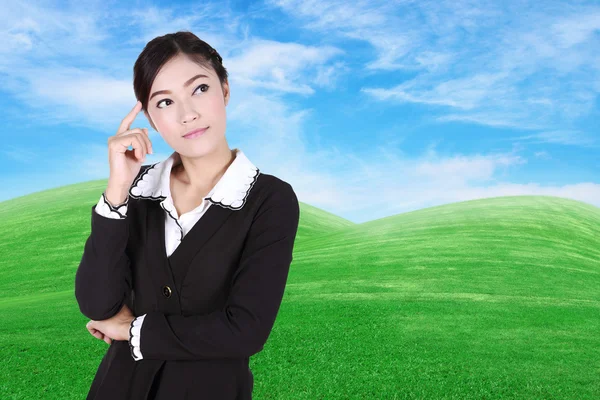 Donna d'affari pensando con campo di erba verde e cielo blu — Foto Stock