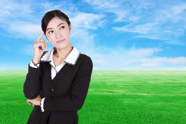 Donna d'affari pensando con campo di erba verde e cielo blu — Foto Stock