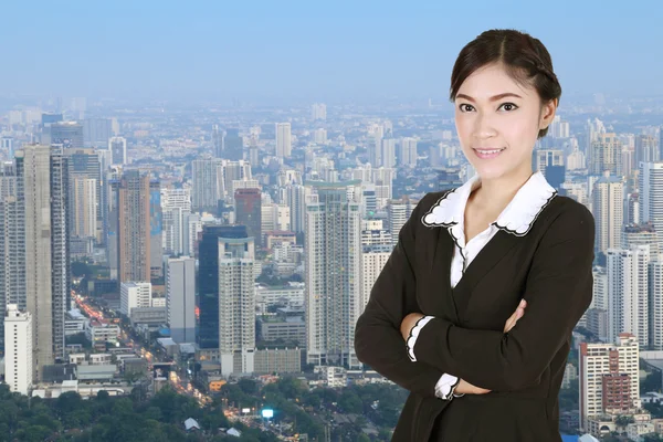 Business woman , crossed arms, with city