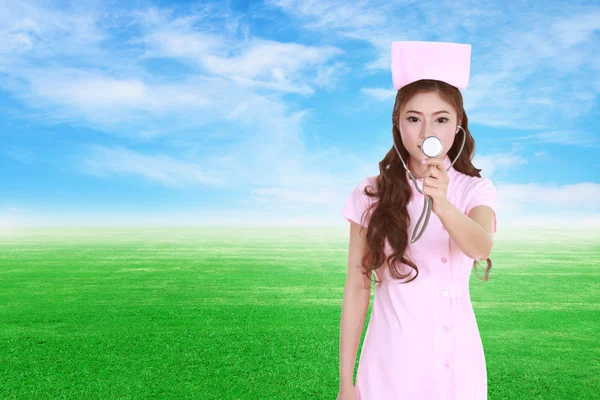 female nurse with stethoscope with green grass field