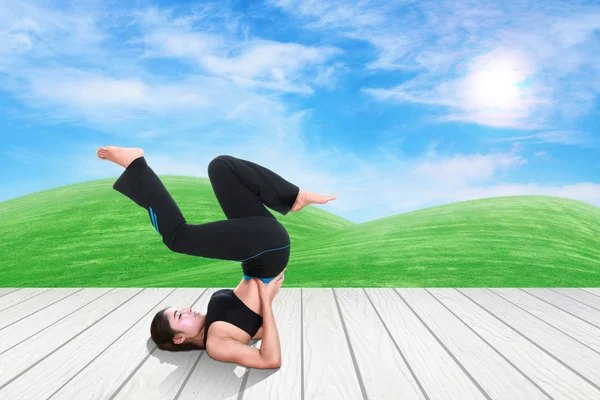 Kobieta robi ćwiczenia jogi na podłogi z drewna z zieloną trawą i niebo — Zdjęcie stockowe