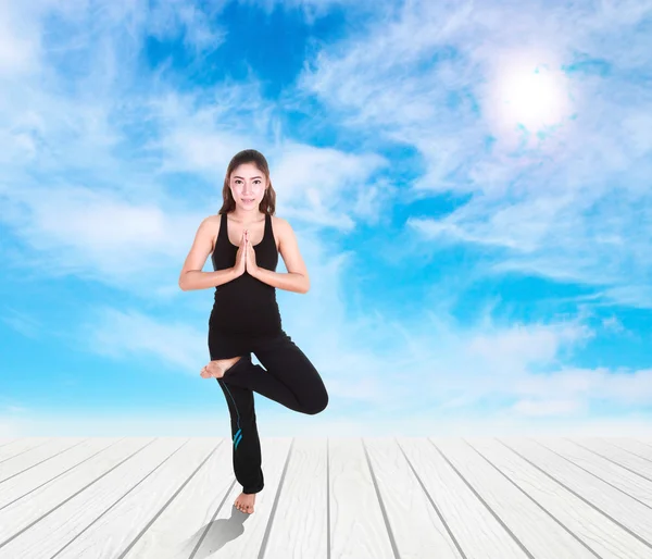 Junge Frau macht Yoga-Übungen auf Holzboden — Stockfoto
