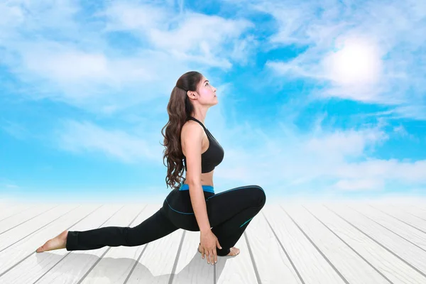 Mujer joven haciendo ejercicio de yoga en suelo de madera — Foto de Stock