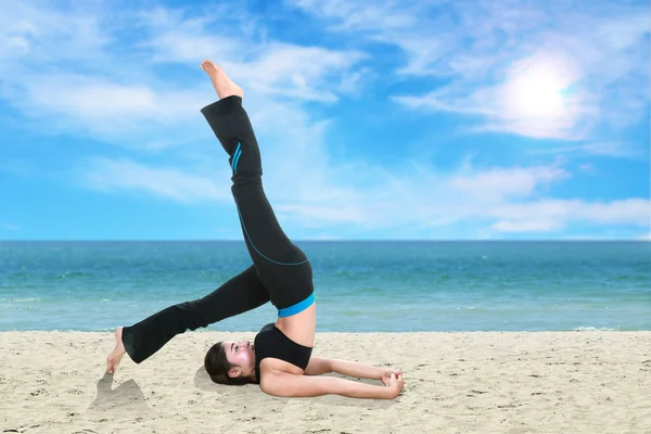 Mulher fazendo exercício de ioga na praia — Fotografia de Stock