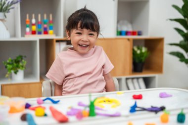 toddler girl with sculpting from plasticine at home