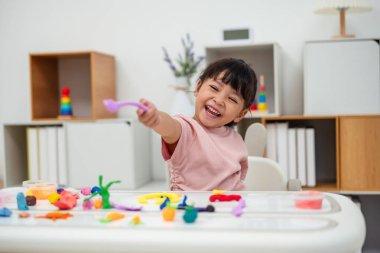 toddler girl with sculpting from plasticine at home