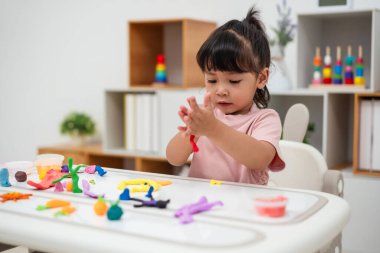 toddler girl with sculpting from plasticine at home